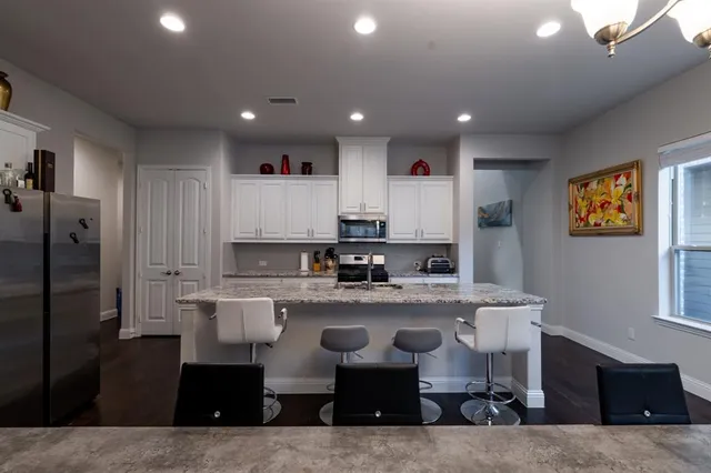 a large kitchen with stainless steel appliances granite countertop a stove and a refrigerator