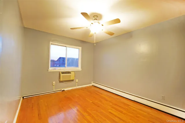 an empty room with a window and a ceiling fan