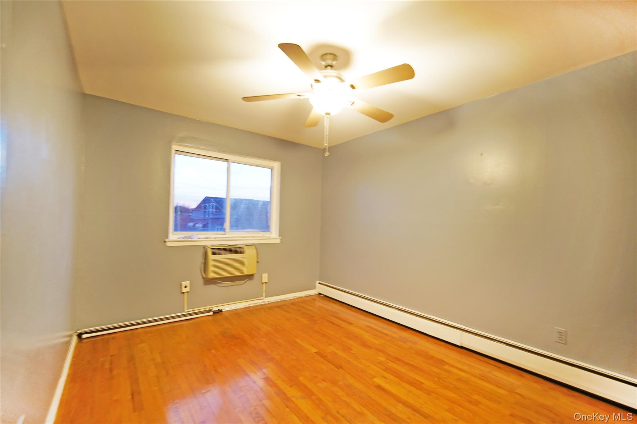 1280 Adee Avenue Bronx, NY 10469 - Photo 4 of 11 an empty room with a window and a ceiling fan