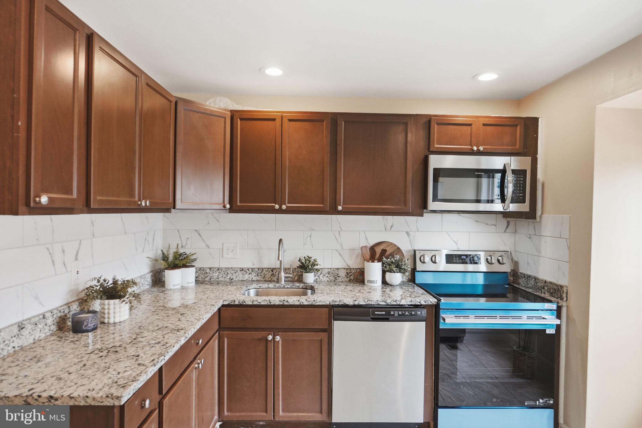 6470 Franconia Court Springfield, VA 22150 - Photo 5 of 31 a kitchen with stainless steel appliances granite countertop a sink stove and cabinets