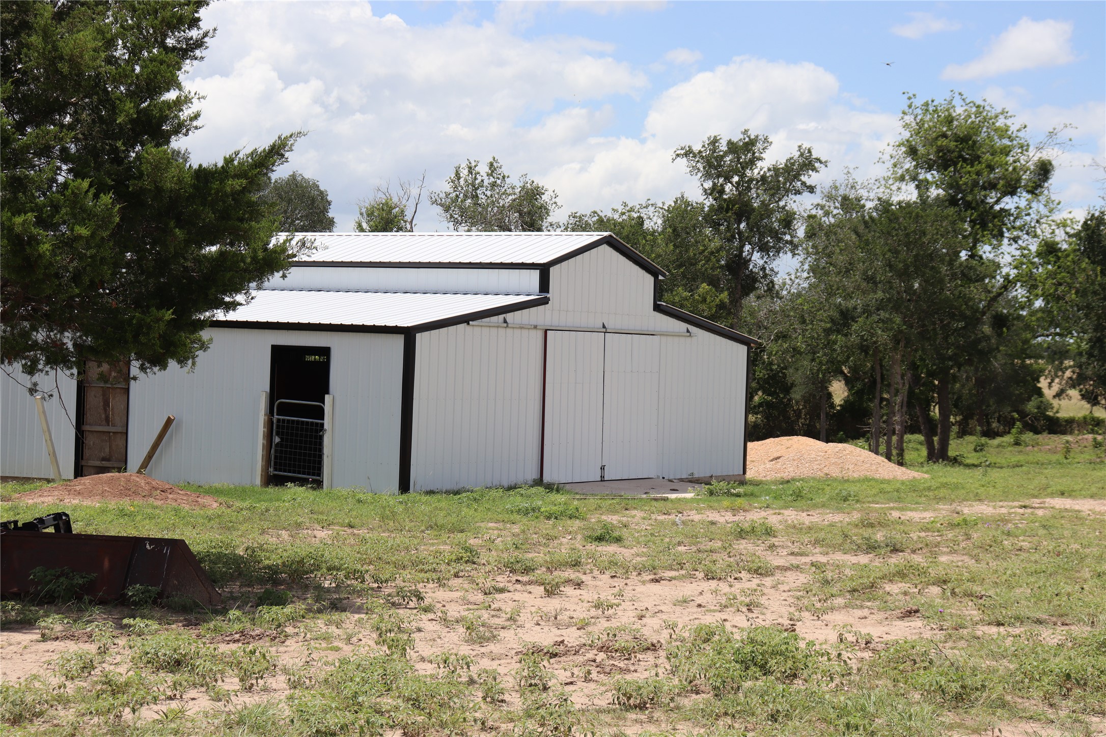 1220 Brushy Branch Road Lockhart, TX 78644 - Photo 14 of 14 A well-maintained barn offers versatile utility amidst a verdant landscape.