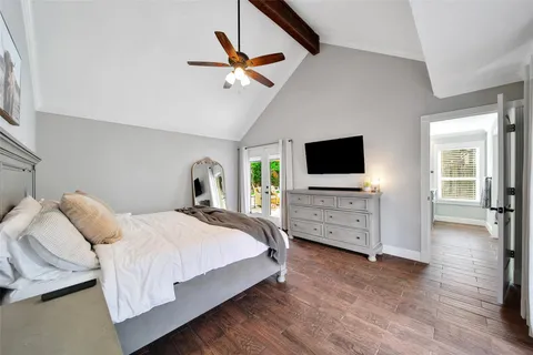 a bedroom with a bed tv and a window