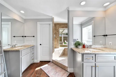 a en suite bathroom with a granite countertop sink and a mirror