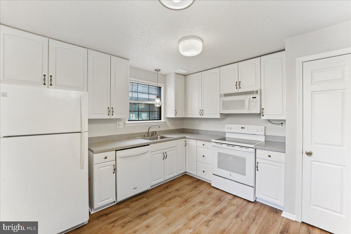 44 Witherspoon Court, Unit 137 Chesterbrook, PA 19087 - Photo 7 of 26 a kitchen with white cabinets and white appliances