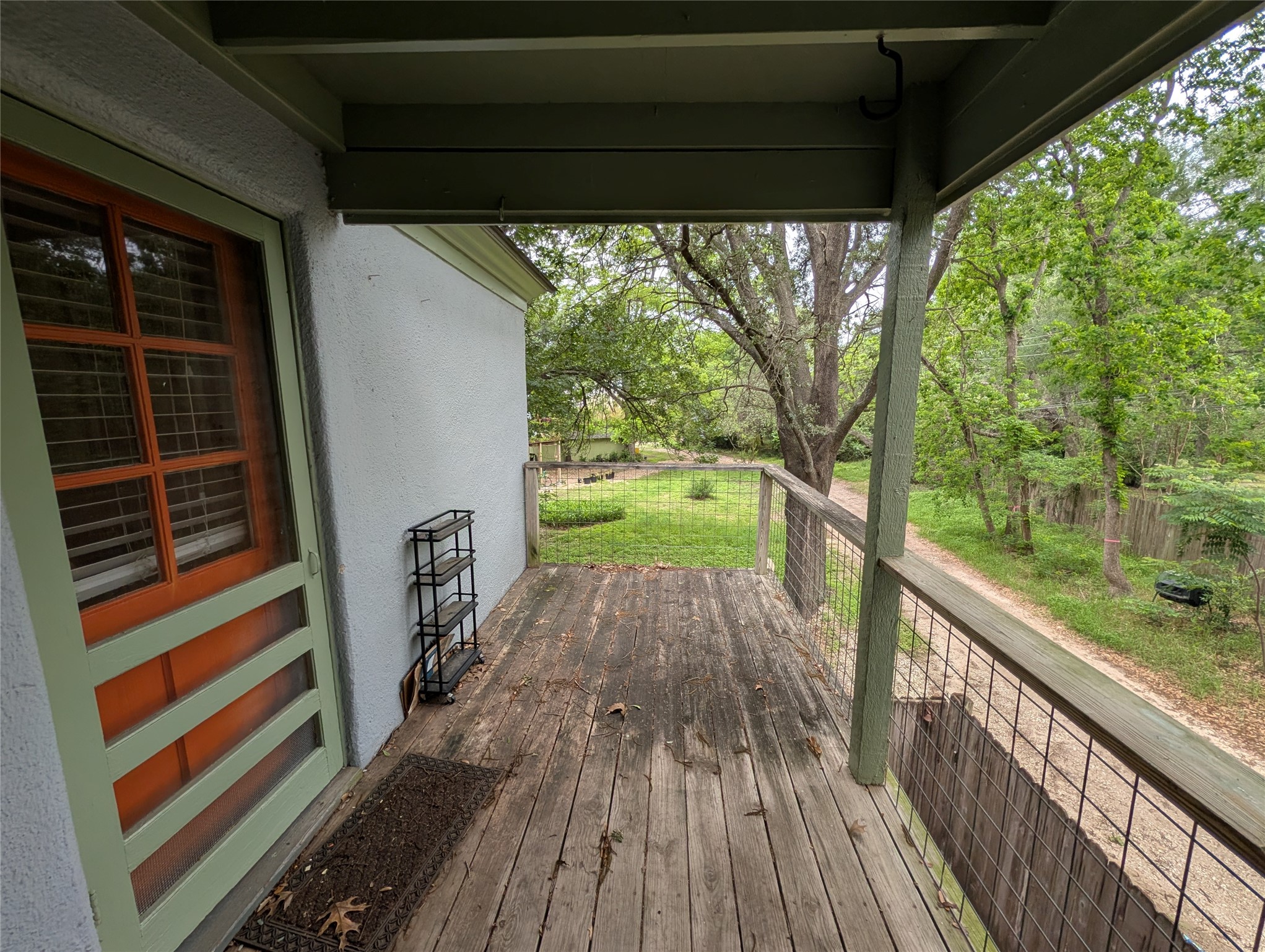 1302 Kirkwood Road, Unit B Austin, TX 78722 - Photo 11 of 12 Outdoor balcony featuring wood-finish flooring, a wood railing with wire mesh infill, and an overhead awning