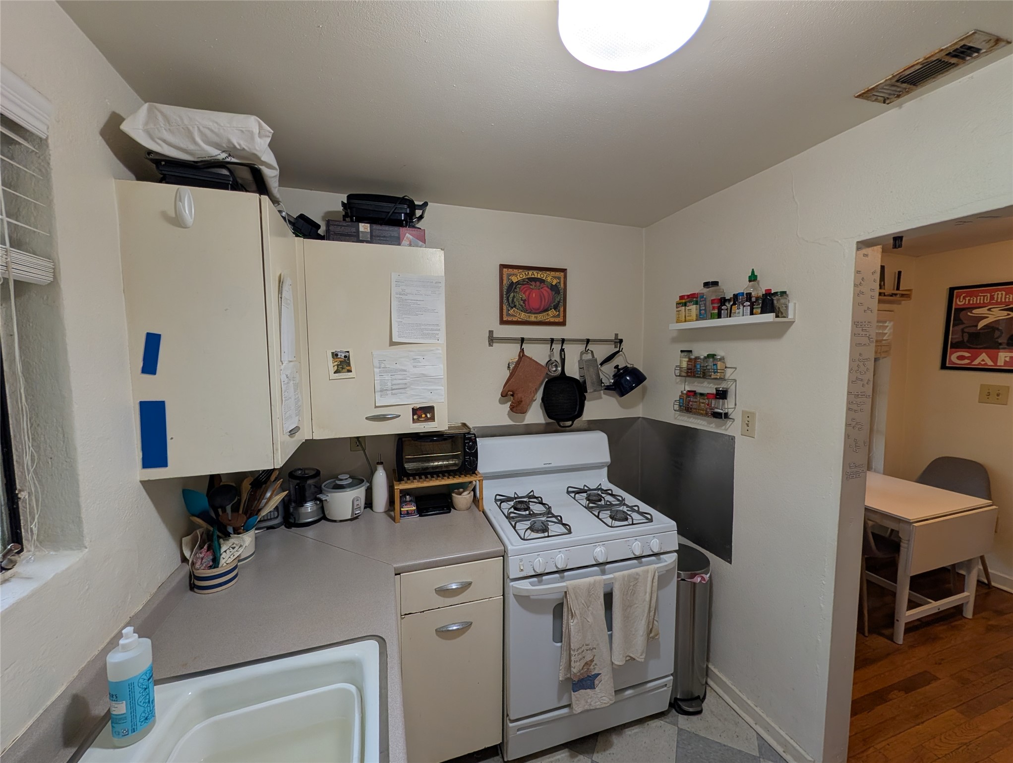 1302 Kirkwood Road, Unit B Austin, TX 78722 - Photo 5 of 12 Compact kitchen featuring light-toned cabinetry and a white gas range