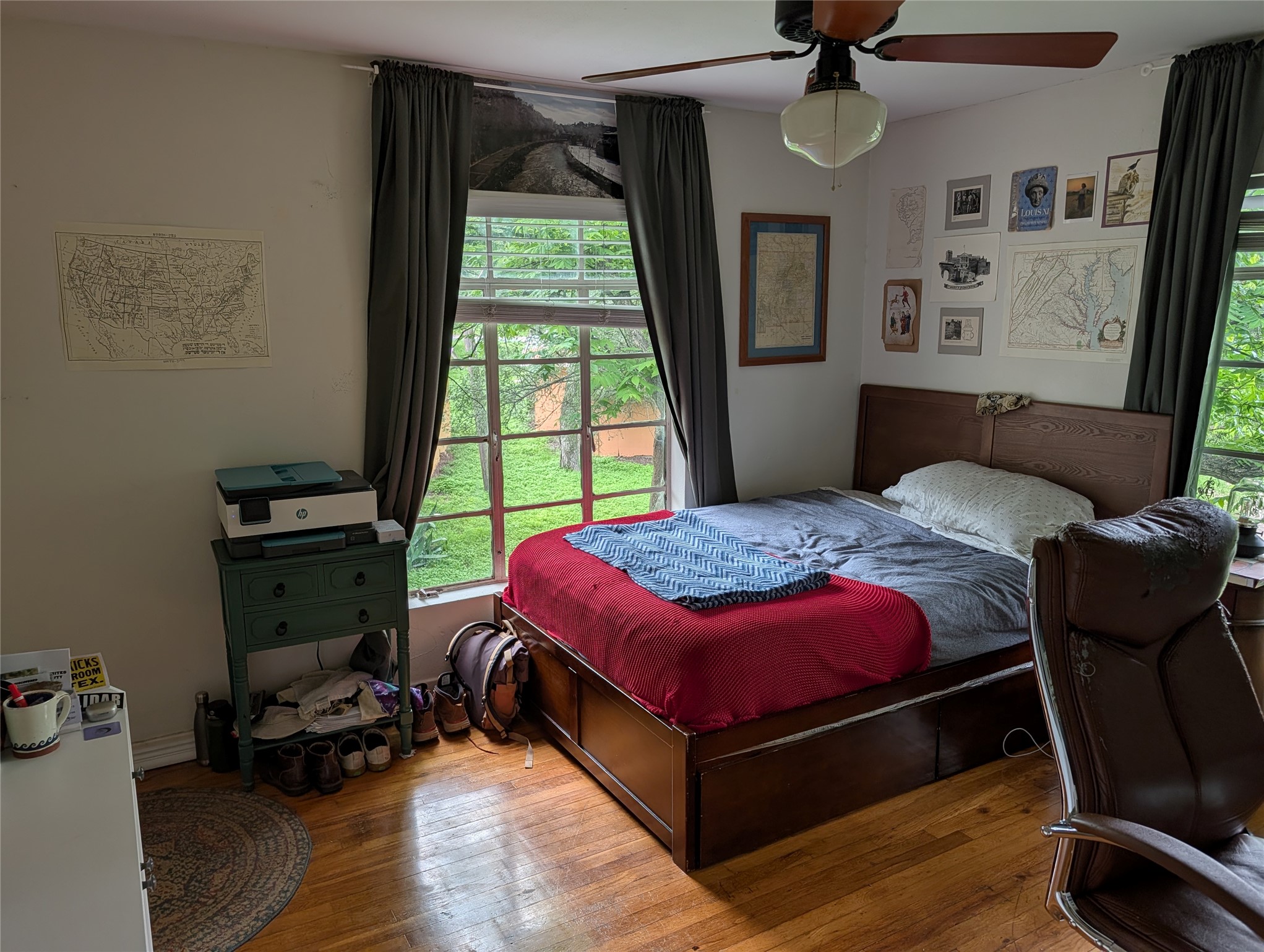 1302 Kirkwood Road, Unit B Austin, TX 78722 - Photo 8 of 12 Spacious room featuring wood-finish flooring, a ceiling fan with light fixture, and two windows providing abundant natural light