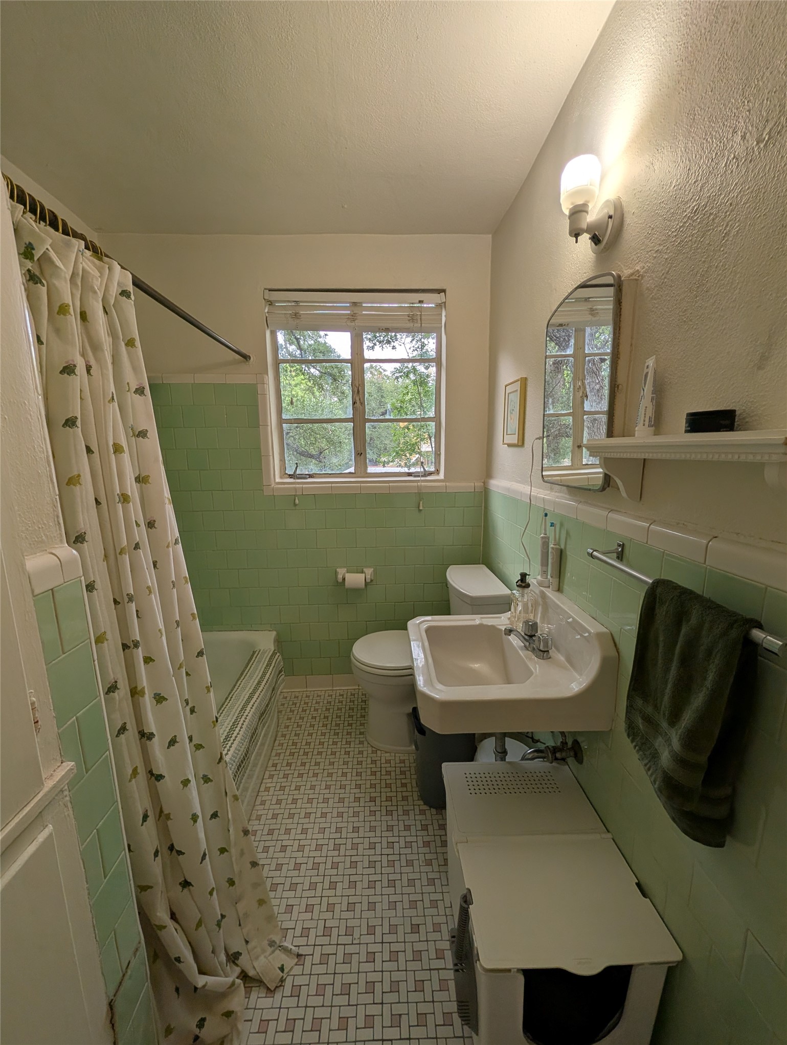 1302 Kirkwood Road, Unit B Austin, TX 78722 - Photo 9 of 12 Bathroom featuring a wall-mounted sink, toilet, and bathtub with green subway tile surround