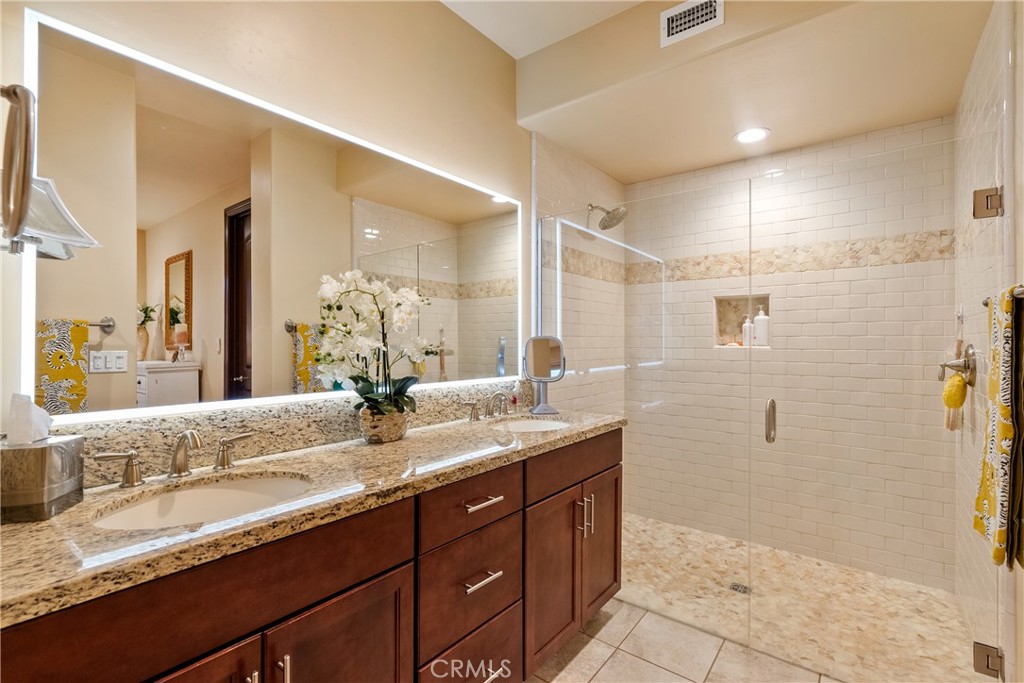9300 Via Castillo Atascadero, CA 93422 - Photo 19 of 49 a bathroom with a granite countertop sink a mirror and a shower