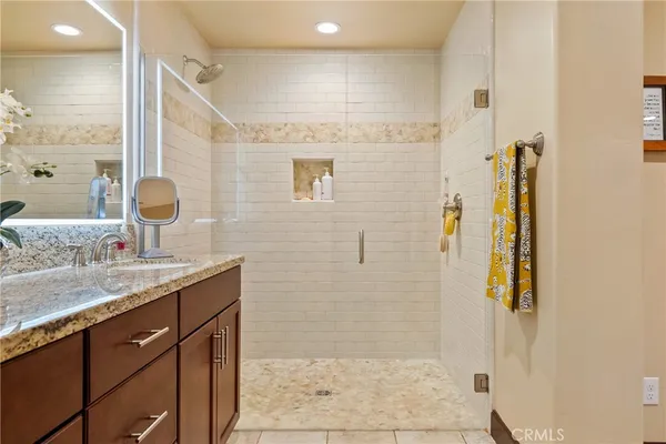 a bathroom with a granite countertop sink a shower and a mirror