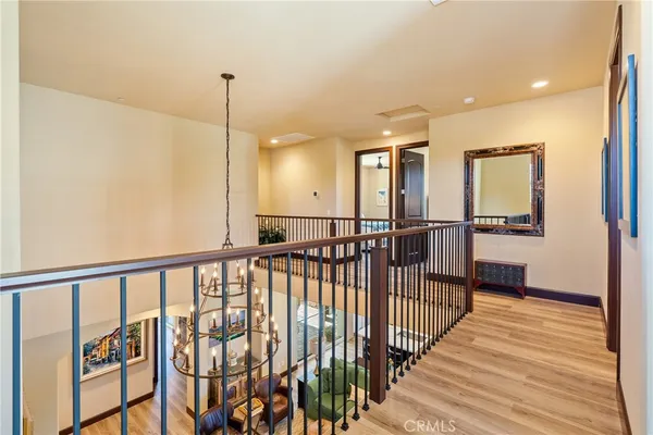 a view of a hallway with wooden floor and stairs
