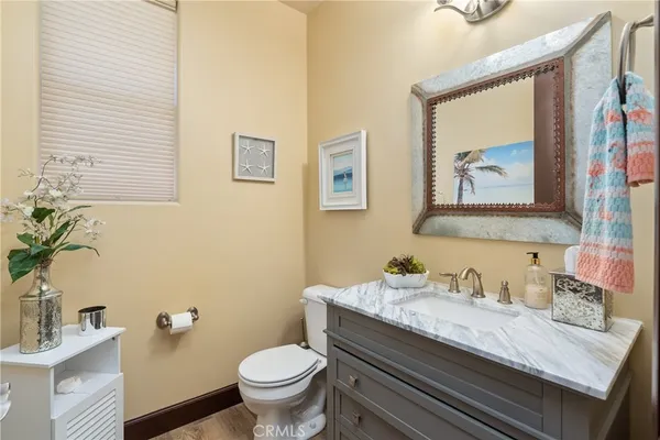 a bathroom with a granite countertop toilet sink and mirror