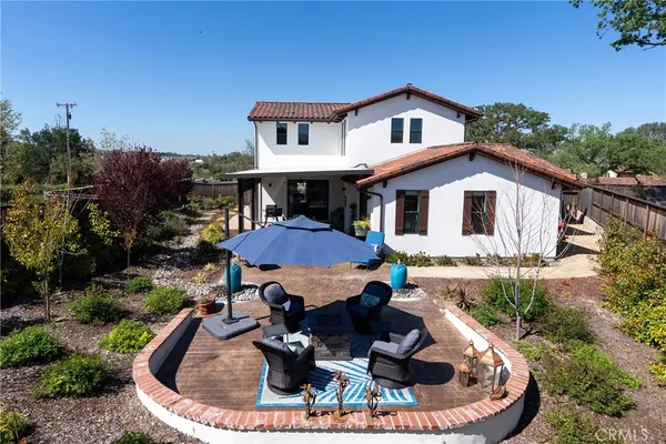 a view of a house with backyard sitting area and fire pit