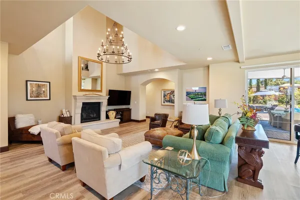 a living room with fireplace furniture and a chandelier