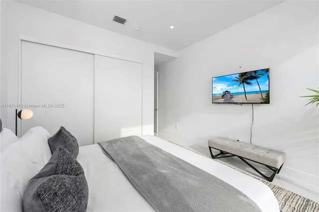 a bedroom with a bed and a large window