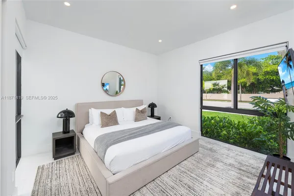 a bedroom with a bed and a flat screen tv