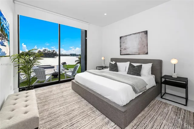 a bedroom with a bed and large windows