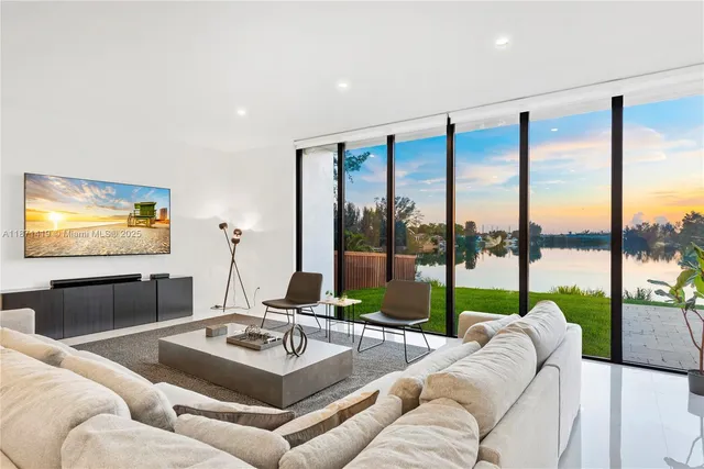 a living room with furniture and floor to ceiling windows