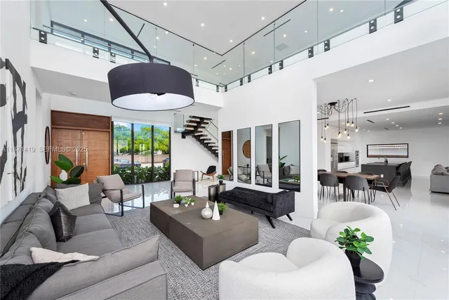 a living room with furniture potted plant floor to ceiling windows and a potted plant