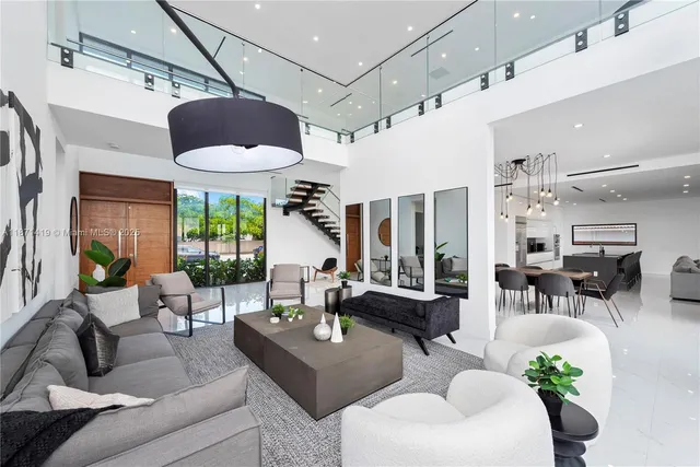 a living room with furniture potted plant floor to ceiling windows and a potted plant