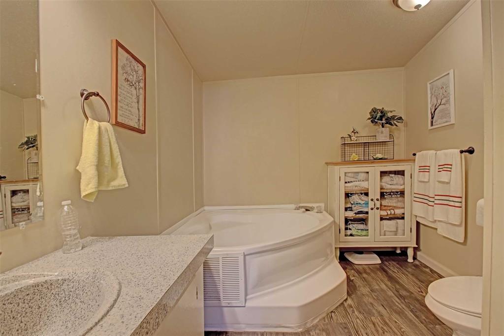 2004 Fall Creek Road Cleburne, TX 76033 - Photo 11 of 18 a bathroom with a granite countertop sink a toilet and bathtub