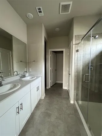 a spacious bathroom with a double vanity sink mirror and shower