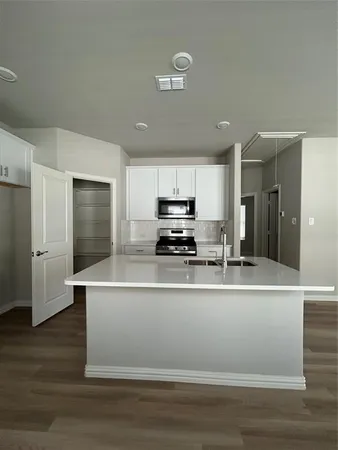 a view of kitchen with stainless steel appliances granite countertop a refrigerator a stove and a sink