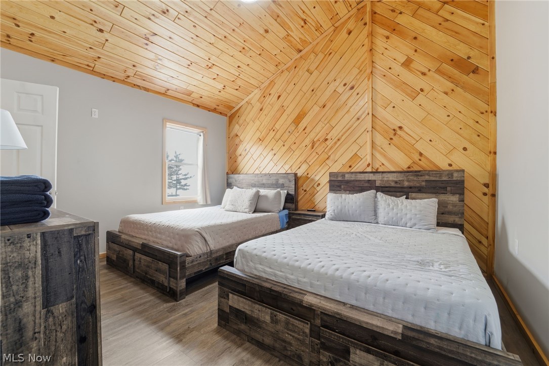 5919 Lake Road West, Unit 33 Ashtabula, OH 44004 - Photo 21 of 22 Bedroom with wooden walls, wood finished floors, and a vaulted wooden ceiling