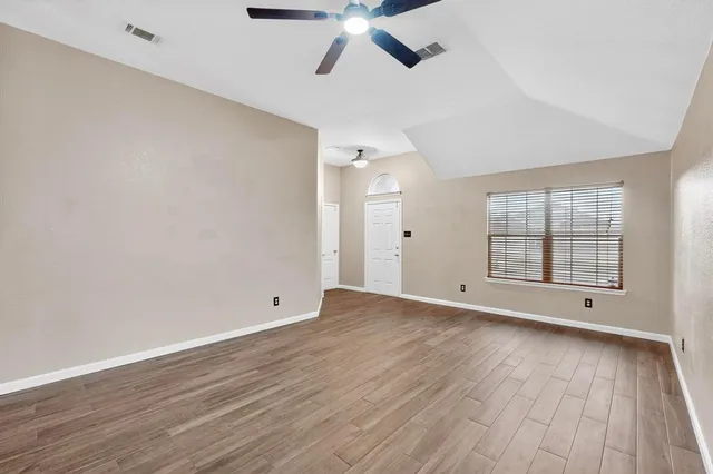 wooden floor in an empty room with a window