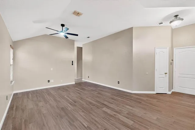 a view of an empty room with wooden floor