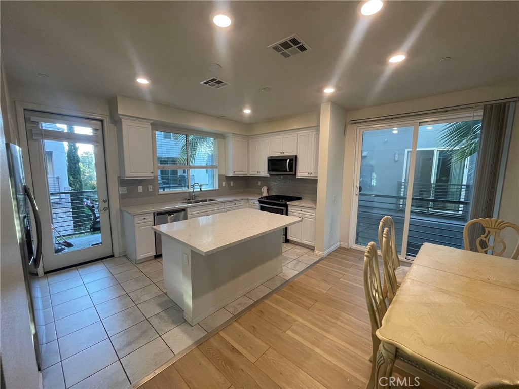 a kitchen with stainless steel appliances granite countertop a sink counter space cabinets and a large window