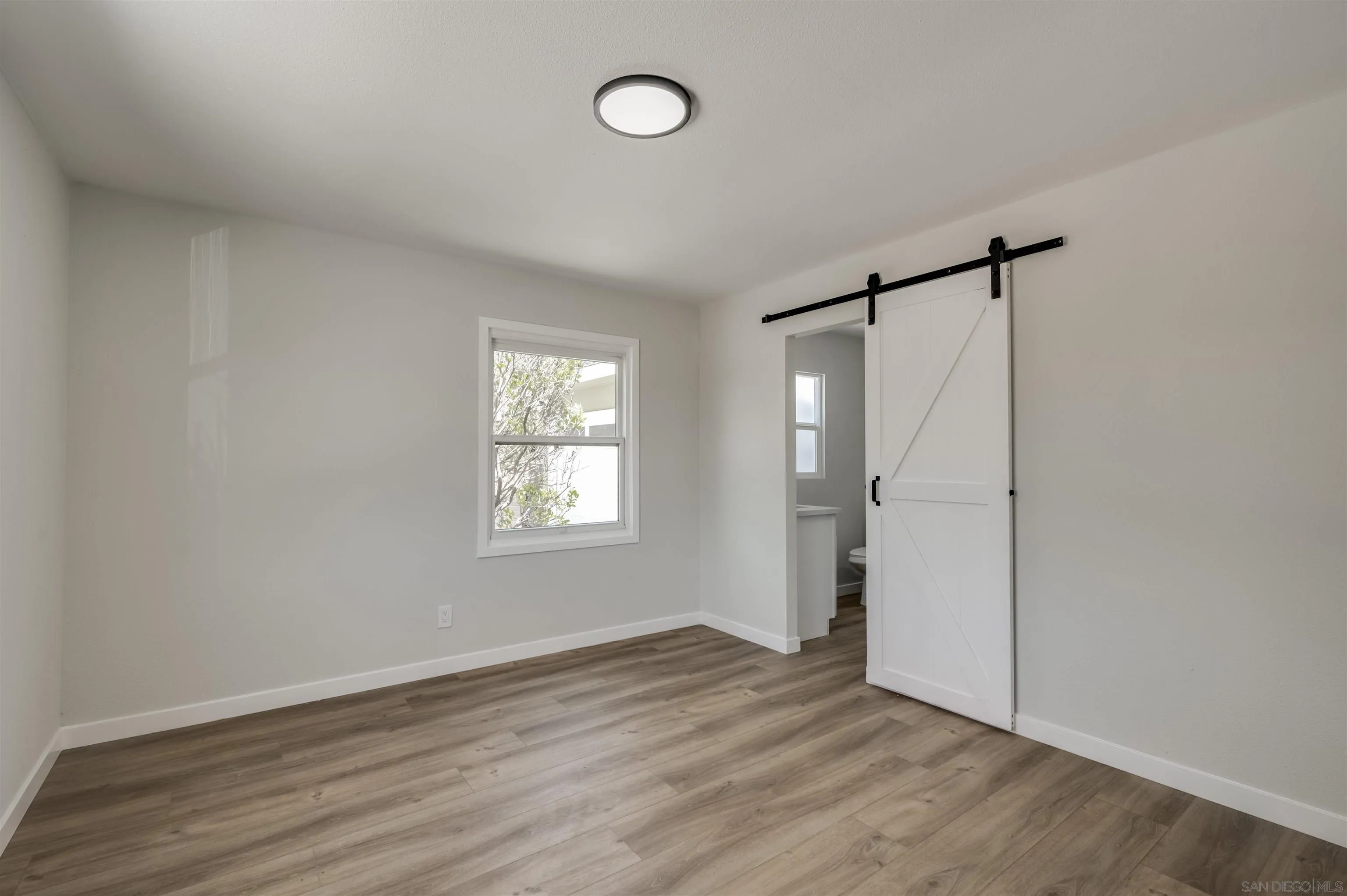 4055 Mt Albertine Avenue San Diego, CA 92111 - Photo 19 of 33 an empty room with wooden floor and windows