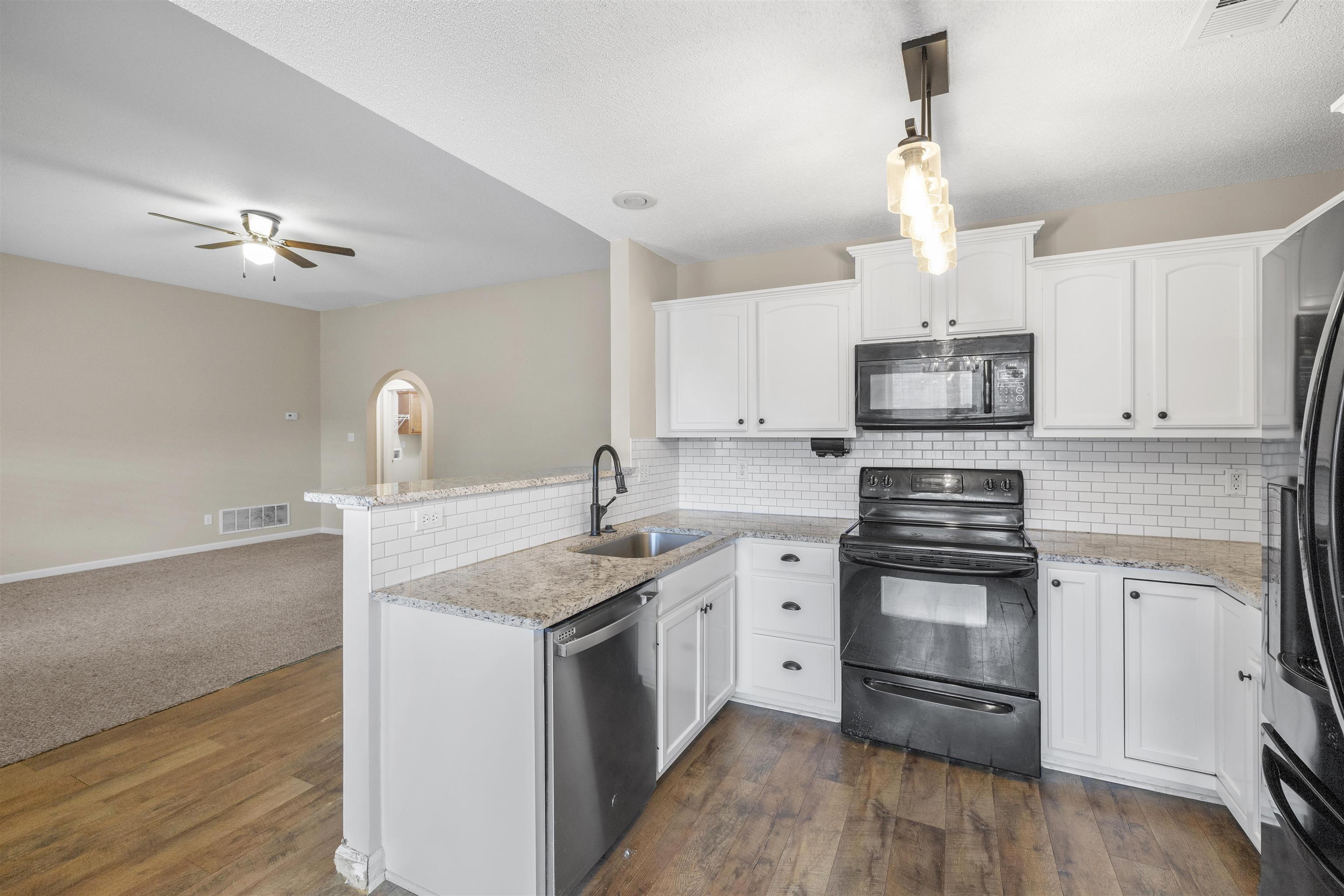 220 Terry Road Somerville, TN 38068 - Photo 12 of 29 a kitchen with kitchen island granite countertop a sink a stove cabinets and wooden floor