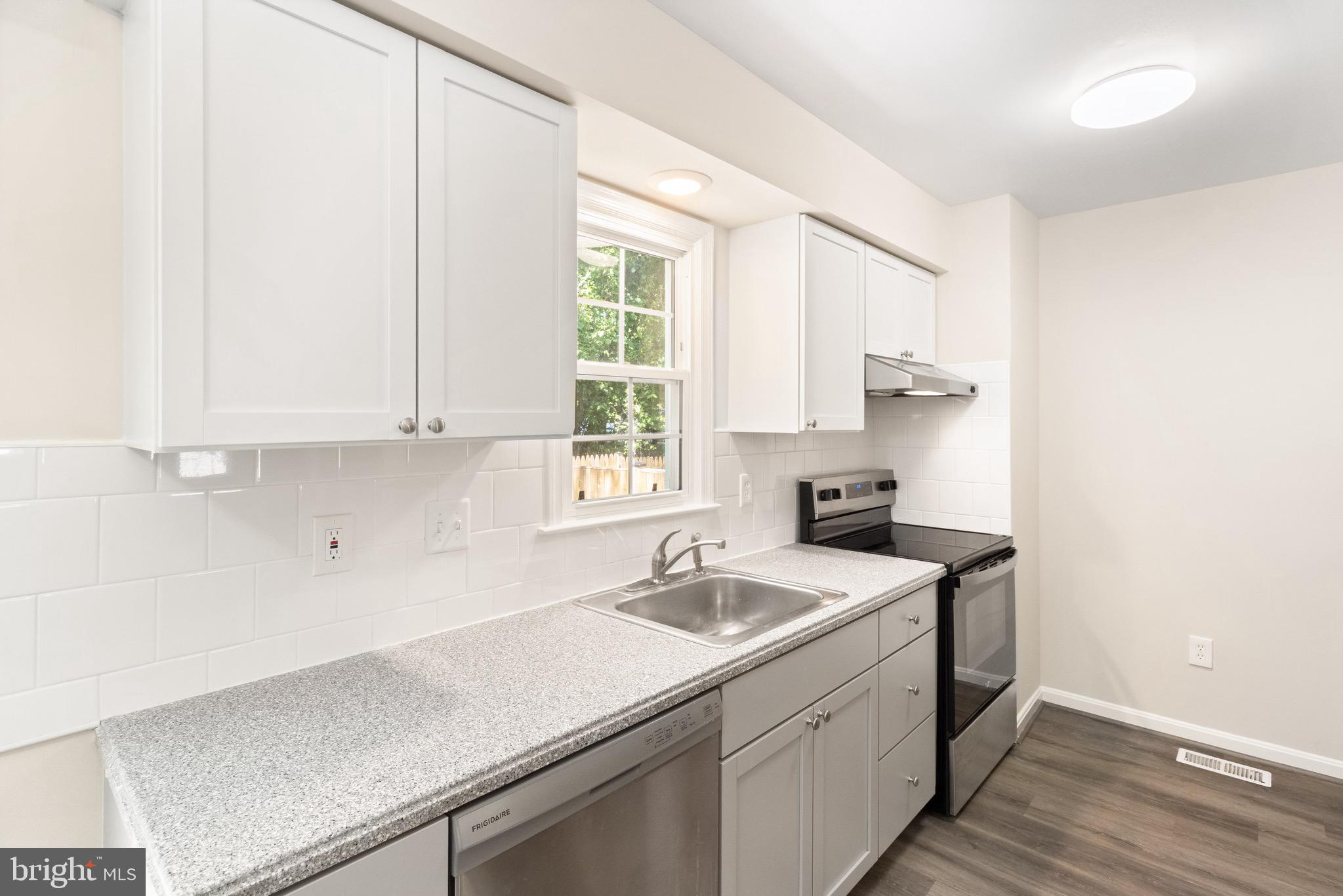8581 Chester Grove Court Springfield, VA 22153 - Photo 10 of 38 a view of a kitchen counter space a sink wooden floor and a window