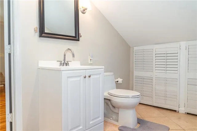 a bathroom with a toilet a sink and mirror