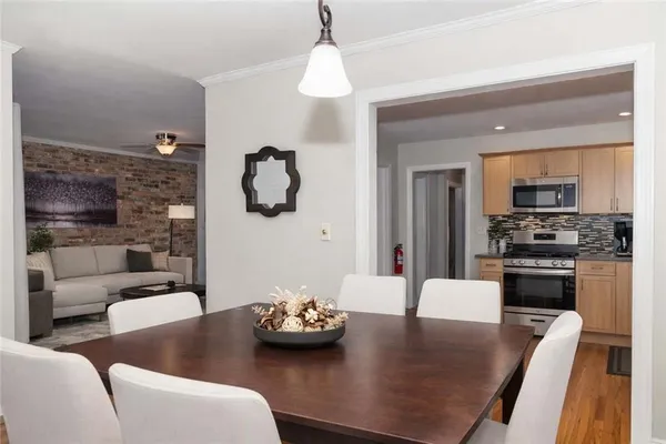 a kitchen with furniture wooden floor and a chandelier