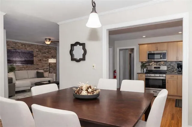 a kitchen with furniture wooden floor and a chandelier