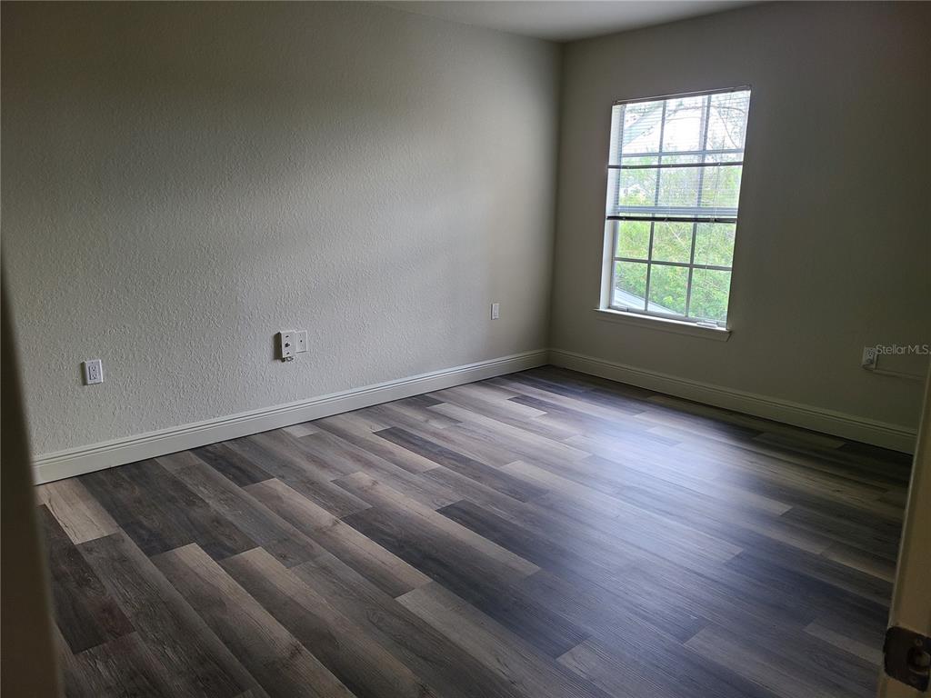 8911 Manor Loop, Unit 205 Lakewood Ranch, FL 34202 - Photo 11 of 33 an empty room with wooden floor and windows