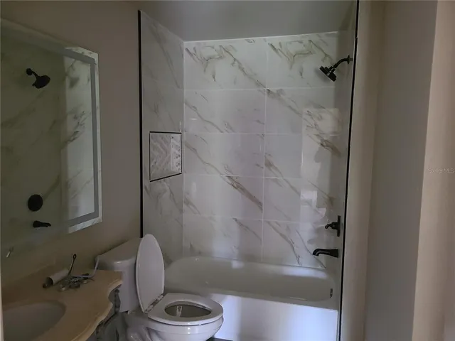 an empty room with a window and a ceiling fan