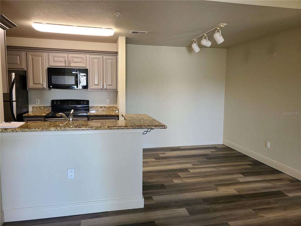 8911 Manor Loop, Unit 205 Lakewood Ranch, FL 34202 - Photo 12 of 33 a view of living room with granite countertop furniture and flat screen tv