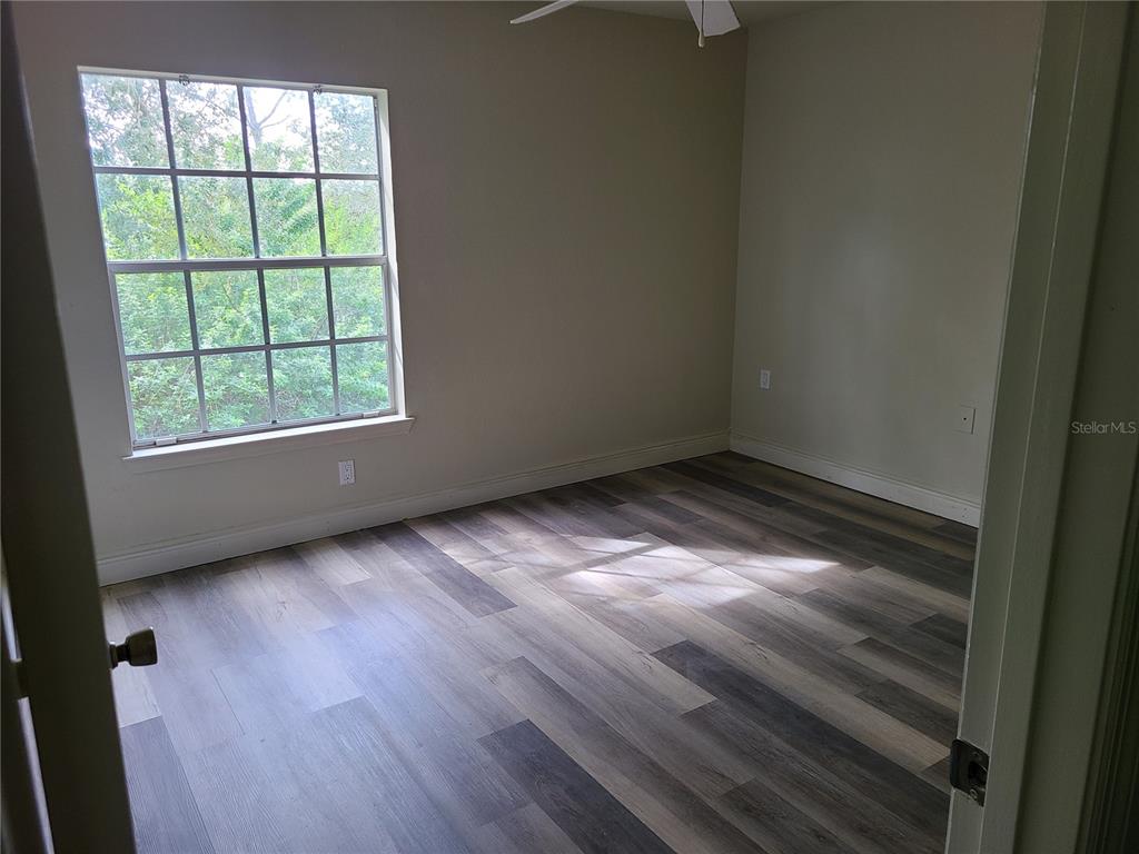 8911 Manor Loop, Unit 205 Lakewood Ranch, FL 34202 - Photo 16 of 33 an empty room with wooden floor and windows