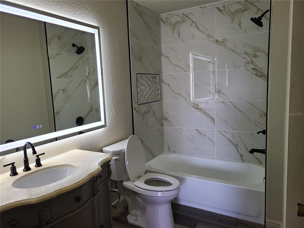 8911 Manor Loop, Unit 205 Lakewood Ranch, FL 34202 - Photo 18 of 33 a bathroom with a sink toilet and shower
