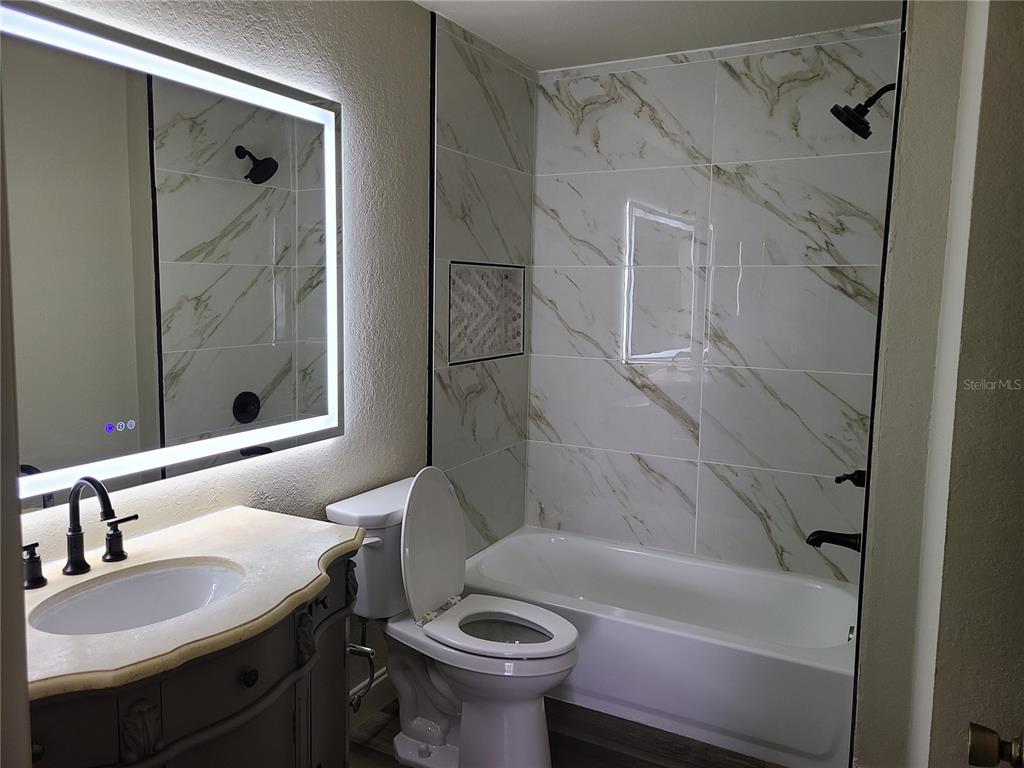 8911 Manor Loop, Unit 205 Lakewood Ranch, FL 34202 - Photo 20 of 33 a bathroom with a sink toilet and shower
