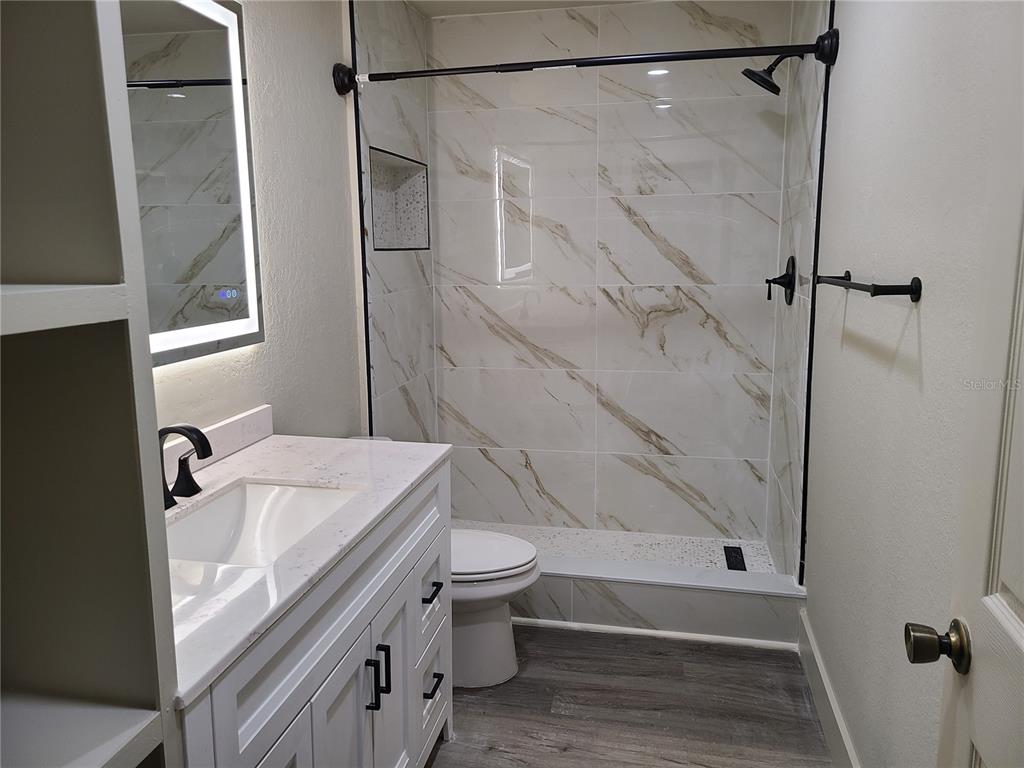 8911 Manor Loop, Unit 205 Lakewood Ranch, FL 34202 - Photo 23 of 33 a bathroom with a sink toilet and shower