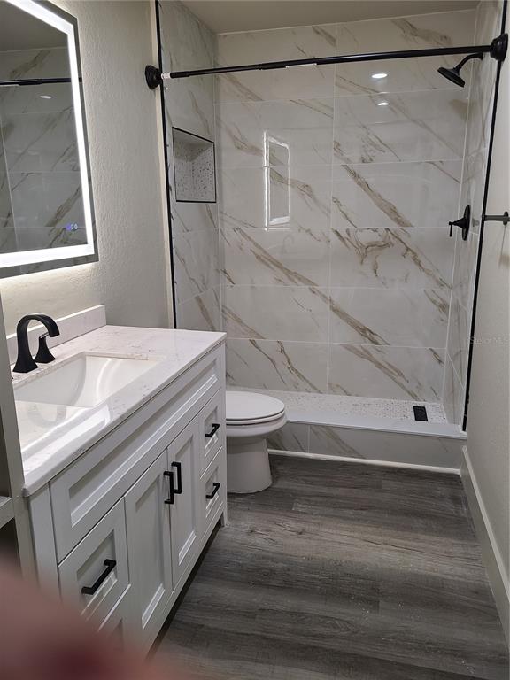 8911 Manor Loop, Unit 205 Lakewood Ranch, FL 34202 - Photo 26 of 33 a bathroom with a sink a toilet and shower