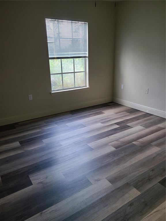 8911 Manor Loop, Unit 205 Lakewood Ranch, FL 34202 - Photo 28 of 33 an empty room with wooden floor and windows