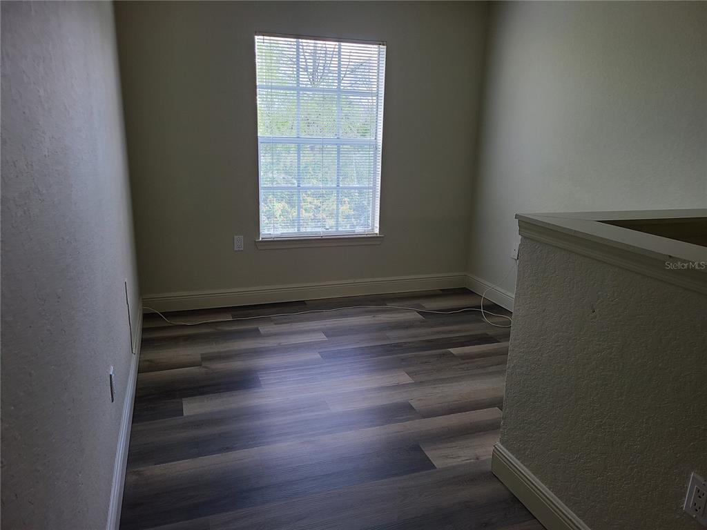 8911 Manor Loop, Unit 205 Lakewood Ranch, FL 34202 - Photo 31 of 33 an empty room with wooden floor and windows