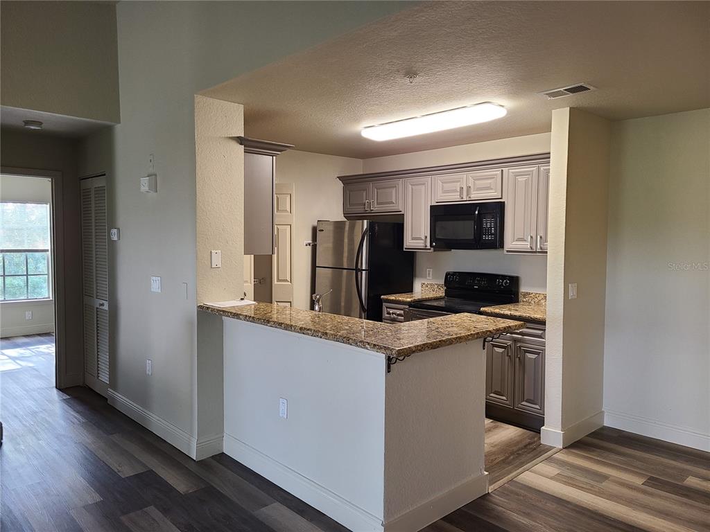 8911 Manor Loop, Unit 205 Lakewood Ranch, FL 34202 - Photo 6 of 33 a kitchen with a sink a counter top space cabinets and stainless steel appliances