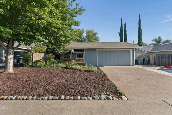 a front view of a house with a garden and yard
