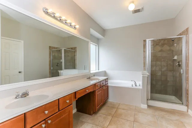 a spacious bathroom with a granite countertop sink a toilet a mirror and shower